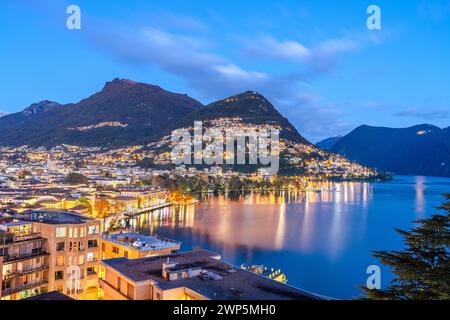 Lugano, Svizzera paesaggio urbano con Monte Bre sul Lago di Lugano di notte. Foto Stock