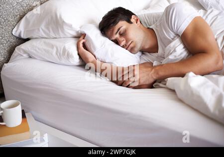 Uomo, riposo e letto per pace, benessere e dormire in pigiama e camera da letto per casa e occhi chiusi. Uomo muscoloso, rilassarsi e sognare a casa Foto Stock