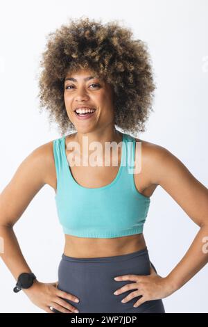 La giovane donna birazziale sorride con fiducia nell'abbigliamento sportivo Foto Stock