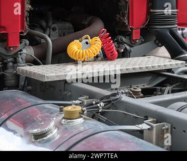 meccanici nella parte posteriore, grande motore v8 sotto la cabina e sistema di tubi flessibili pneumatici di un veicolo Foto Stock