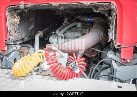 Dettaglio dei meccanici nella parte posteriore, grande motore v8 sotto la cabina e sistema di tubi flessibili pneumatici di un veicolo Foto Stock