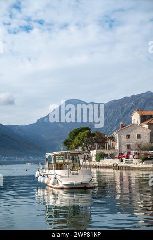 Una piccola barca situata tra le montagne del mare Adriatico. Perast, Montenegro Foto Stock