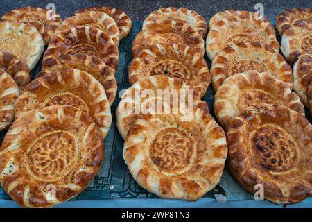 Vista ravvicinata del delizioso pane fresco tradizionale conosciuto come non aka naan o lepeshka su una bancarella del mercato, Khujand, Tagikistan Foto Stock