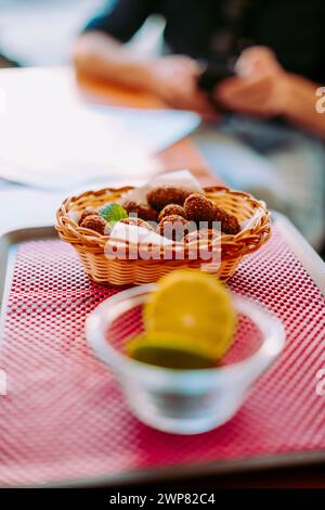 Deliziose crocchette di pollo nel cestino sul tavolo del ristorante, Portogallo Foto Stock