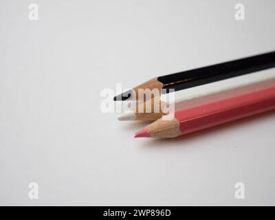 Primo piano di matite colorate assortite disposte su una superficie bianca del tavolo Foto Stock