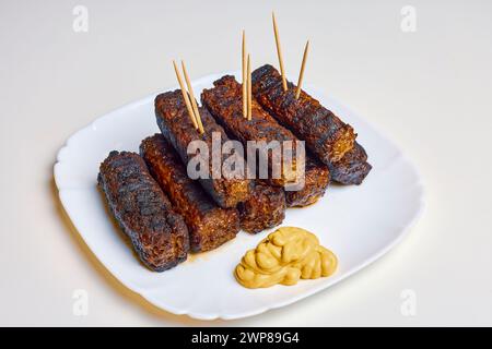 Involtini di carne chiamati (mici) su un piatto, cibo tradizionale rumeno. Foto Stock