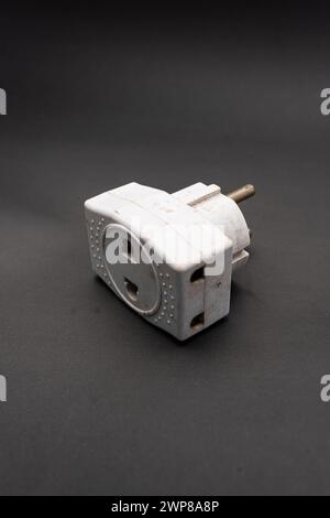Rubinetto di uscita triplo usato sporco. Adattatore di energia elettrica utilizzato per dividere la presa utilizzata per i viaggi. Adattatore elettrico isolato su sfondo nero. Foto Stock