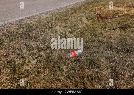 Lettiera nell'erba lungo la strada Foto Stock