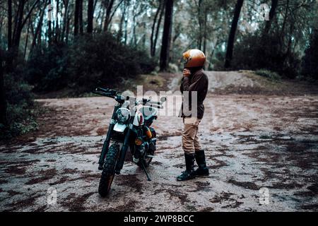 Un uomo con una giacca di pelle che indossa un casco in moto Foto Stock