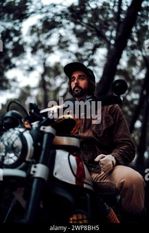 Un colpo verticale ad angolo basso di un uomo seduto su una moto Foto Stock