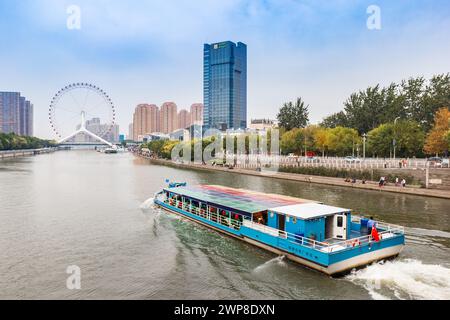 Crociera in barca turistica verso la ruota panoramica Tianjin Eye a Tianjin, Cina Foto Stock