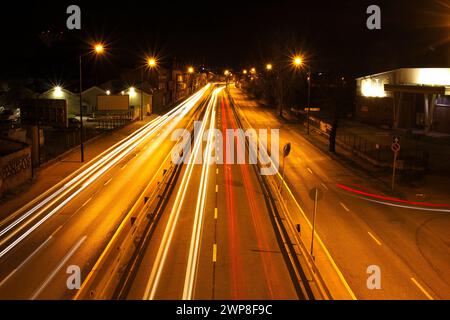 Una lunga esposizione di percorsi leggeri su una strada della città di notte Foto Stock