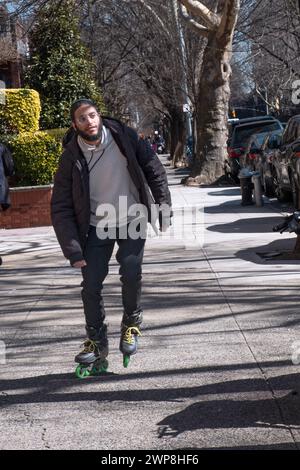 Un ebreo ortodosso sul pattinaggio a rotelle a Crown Street a Crown Heights, Brooklyn, New York. Foto Stock