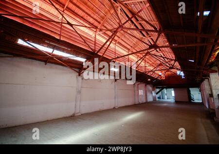 Una spaziosa sala vuota con soffitto illuminato in un vecchio edificio Foto Stock