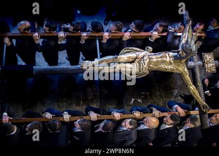 I devoti portano una scultura di Cristo del XVII secolo durante la via Crucis a Siviglia. Foto Stock