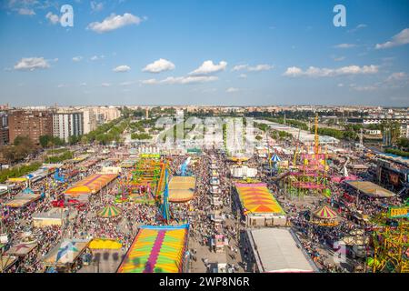 Le folle apprezzano giostre e attrazioni presso la vivace Fiera di aprile di Siviglia. Foto Stock