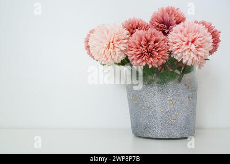 Bouquet di fiori artificiali in spugna rosa in vaso grigio argento su sfondo bianco. Natura morta, opzione decorazione interna. Arredamento della camera. Spazio libero Foto Stock