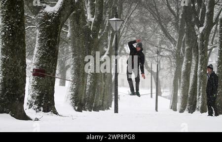 05/02/13 Matt Stevens, 19 anni, pratica slacklining lungo una linea tra gli alberi di Buxton, Derbyshire, durante le forti nevicate. La neve dà una S. Foto Stock