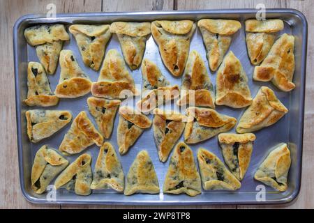 pasticcini ripieni al forno su sfondo in marmo nero pronti per essere serviti e spostati dal vassoio di alluminio alle ciotole sul tavolo della cena o nella borsa per bambini Foto Stock