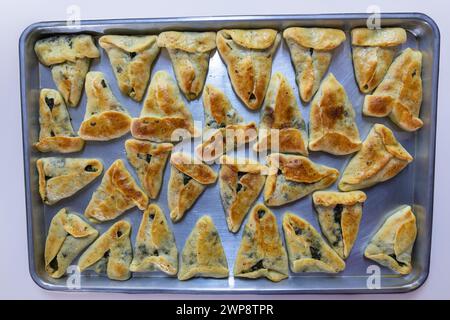 pasticcini ripieni al forno su sfondo in marmo nero pronti per essere serviti e spostati dal vassoio di alluminio alle ciotole sul tavolo della cena o nella borsa per bambini Foto Stock