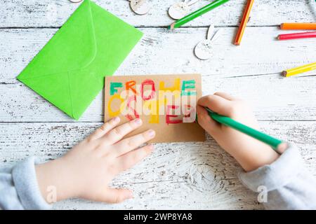 3 marzo 2024: Bambini che fanno decorazioni pasquali, scrittura a mano con matite colorate: Buona Pasqua *** Kind beim Basteln von Osterdekoration, Hand schreibt mit Buntstiften: Frohe Ostern Foto Stock
