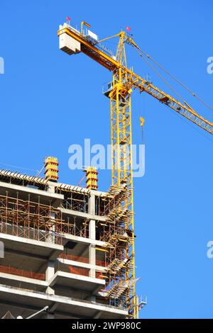 Costruzione Crane e l'edificio in costruzione con cielo blu sullo sfondo Foto Stock