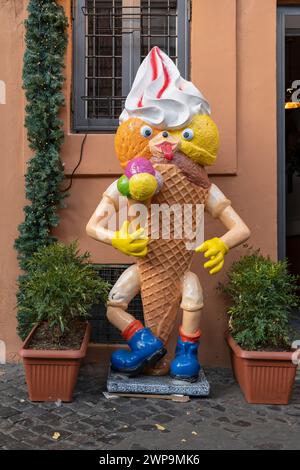 Grande cartello con la scultura del cono di gelato fuori da un negozio di gelateria in una strada del quartiere di Trastevere. Roma, Italia, Europa, UE Foto Stock