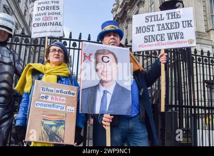 L'attivista anti-Brexit Steve Bray tiene dei cartelli che rendono noti i suoi sentimenti sul Cancelliere dello Scacchiere Jeremy Hunt e sulle tasse britanniche durante una manifestazione fuori Downing Street mentre i manifestanti anti anti-Tory si riuniscono il budget Day. (Foto di Vuk Valcic / SOPA Images/Sipa USA) Foto Stock