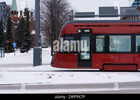 Tram rosso che percorre la strada coperta di neve a Tampere, Finlandia. 27 gennaio 2024. Foto Stock