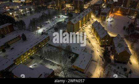 Fotografia con droni di appartamenti, strade e parcheggi coperti di neve durante la mattina nuvolosa d'inverno Foto Stock