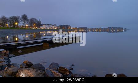 Dalla banchina presso la spiaggia cittadina di Hoorn, si gode di una buona vista dello skyline di Hoorn. Il Markermeer è come uno specchio, creando un bel riflesso. Foto Stock