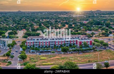 Vista aerea del CBD, Gaborone, Botswana, incrocio e auto, area commerciale e residenziale insieme, al tramonto Foto Stock
