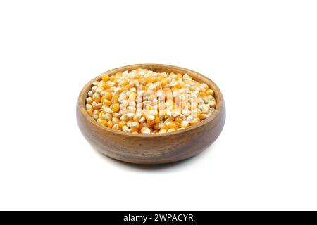 Popcorn non ricoperto in una ciotola di legno su sfondo bianco. Un tipo di mais che si espande dal chicco e si gonfia quando viene riscaldato. Semi gialli, commestibili, crudi Foto Stock