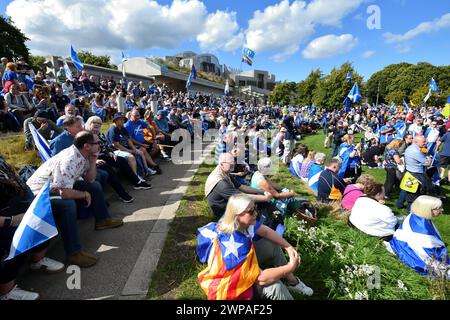 Una grande folla scozzese seduta al sole all'Holyrood parliament di Edimburgo, dopo una pacifica marcia per l'indipendenza "credere in Scozia". Foto Stock