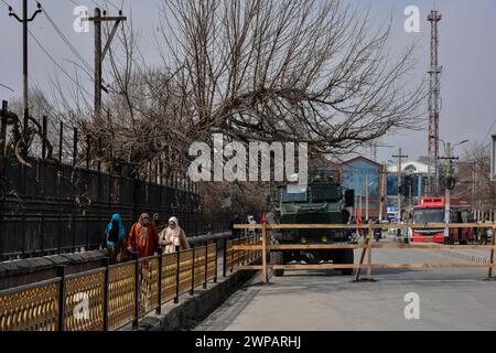 Srinagar, India. 6 marzo 2024. Le donne kashmiri passano davanti a una barricata eretta dalle forze governative vicino al luogo in cui il primo ministro indiano Narendra modi dovrebbe affrontare una manifestazione pubblica. La sicurezza è stata rafforzata in Kashmir in vista della manifestazione del primo ministro Narendra modi a Srinagar il 7 marzo. Questa sarebbe la prima visita del primo Ministro in Kashmir dopo l'abrogazione dell'articolo 370 nell'agosto 2019. Credito: SOPA Images Limited/Alamy Live News Foto Stock