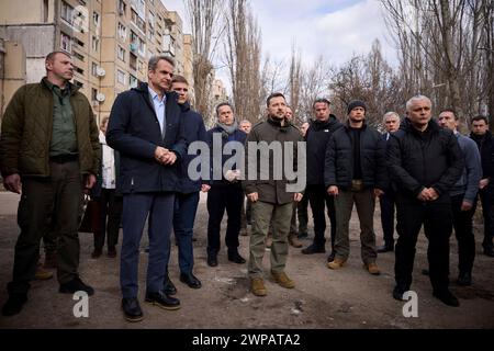 Odessa, Ucraina. 6 marzo 2024. Il presidente ucraino Volodymyr Zelenskyy, centro, e il primo ministro greco Kyriakos Mitsotakis, a sinistra, visitano un edificio residenziale distrutto dove un drone russo ha ucciso 12 civili, il 6 marzo 2024 a Odesa, Ucraina. Più tardi, nel corso della giornata, un altro drone colpì a soli 500 metri dal corteo presidenziale trasportando entrambi i leader. Credito: Presidenza Ucraina/Ufficio stampa presidenziale ucraino/Alamy Live News Foto Stock