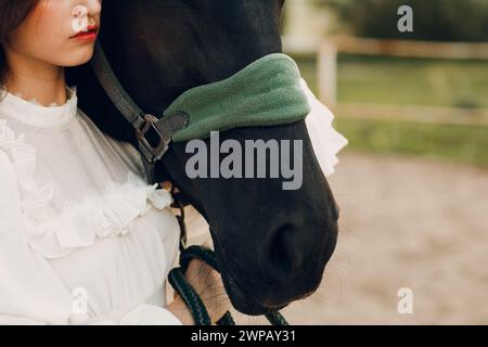 Il ritratto di una donna abbraccia il suo cavallo al ranch all'aperto Foto Stock