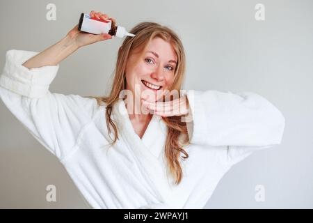 ragazza che applica il prodotto per la crescita dei capelli al cuoio capelluto Foto Stock