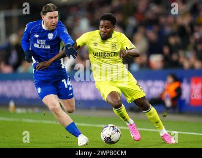 Josh Bowler (a sinistra) di Cardiff City e Jaheim Headley di Huddersfield Town lottano per il pallone durante la partita del campionato Sky Bet al Cardiff City Stadium, Galles. Data foto: Mercoledì 6 marzo 2024. Foto Stock