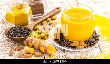 Latte dorato, fatto con curcuma e altre spezie, sana zafferano bevanda, cannella, anice stellato, pepe nero e mandorle Foto Stock