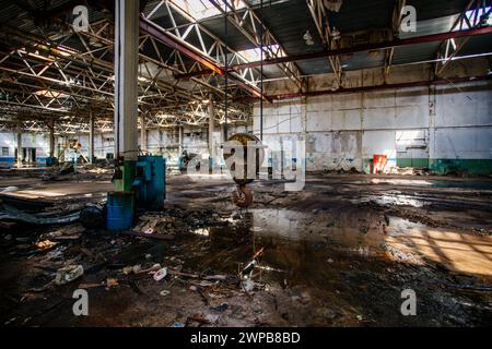 Fabbrica abbandonata. Grande sala industriale in rovina vuota con resti di attrezzature rotti. Foto Stock