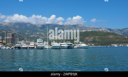 Budva, Montenegro, 15 agosto 2022 mare Adriatico, costa, montagne, increspature di mare. Barche e navi sono ormeggiate sul terrapieno. Parcheggio per il trasporto d'acqua Foto Stock