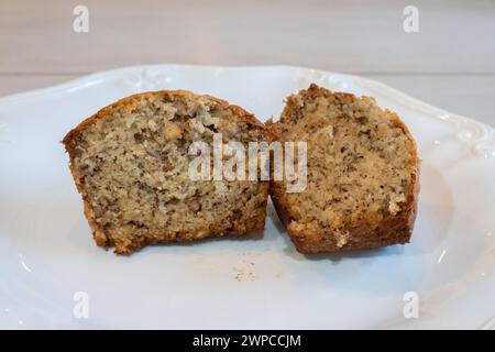 Muffin alle noci di banana appena sfornato, diviso a metà su un piatto bianco. STATI UNITI. Foto Stock