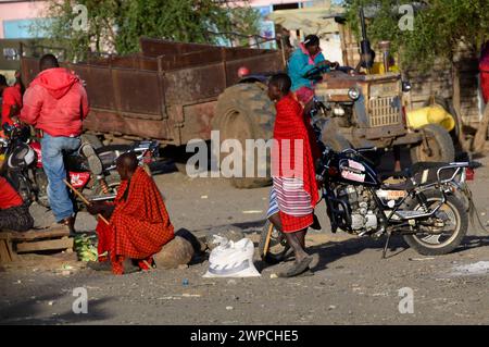 Maasai tribesmen in un colorato bovini e prodotti freschi di mercato nel nord della Tanzania. Foto Stock