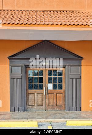 Houston, Texas USA 07-04-2023: Ingresso a doppia porta in un edificio dal design moderno di colore arancione con una tenda isolata. Foto Stock