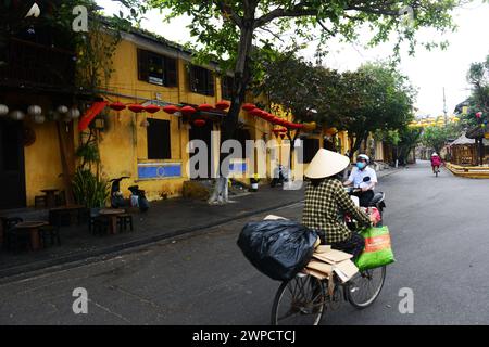 Una donna vietnamita in bicicletta a Hoi An, Vietnam. Foto Stock