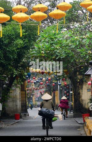 Una donna vietnamita in bicicletta a Hoi An, Vietnam. Foto Stock