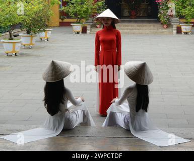 Modelle vietnamite in una foto al tempio buddista Hoa Van le Nghia nella città vecchia di Hoi An, Vietnam. Foto Stock