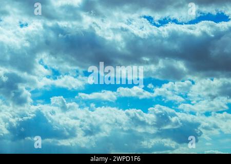 Un cielo pieno di soffici nuvole bianche su uno sfondo blu profondo Foto Stock