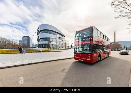 Tour della città di Stoccarda. Stadtrundfahrt im roten Doppeldecker. Stadtansicht Stuttgart vor dem Mercedes Museum und der Mercedes Benz Welt a Bad Canntstatt. // 03.03.2024: Stoccarda, Baden-Württemberg, Deutschland, Europa *** tour della città di Stoccarda in un autobus rosso a due piani vista della città di Stoccarda di fronte al Museo Mercedes e al Mercedes Benz World a Bad Canntstatt 03 03 2024 Stoccarda, Baden Württemberg, Germania, Europa Foto Stock